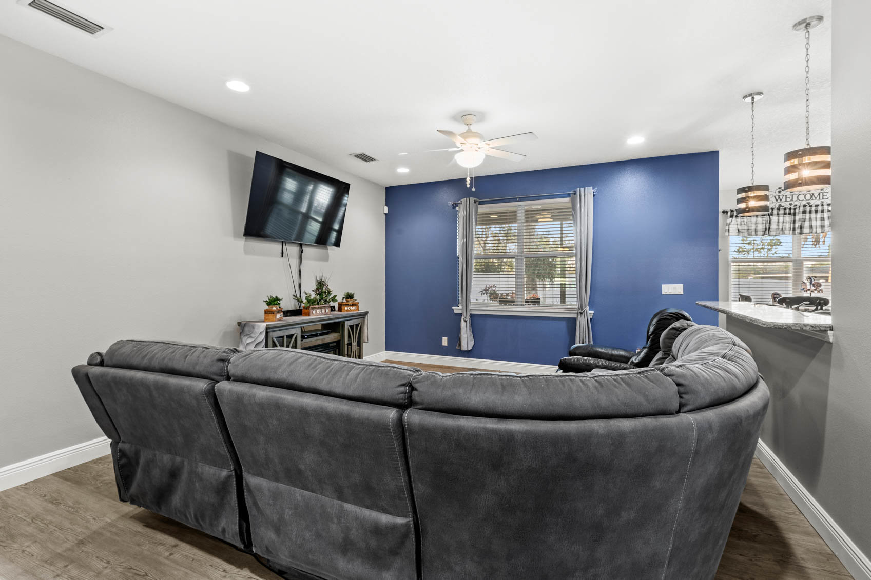living room with blue walls and grey sectional